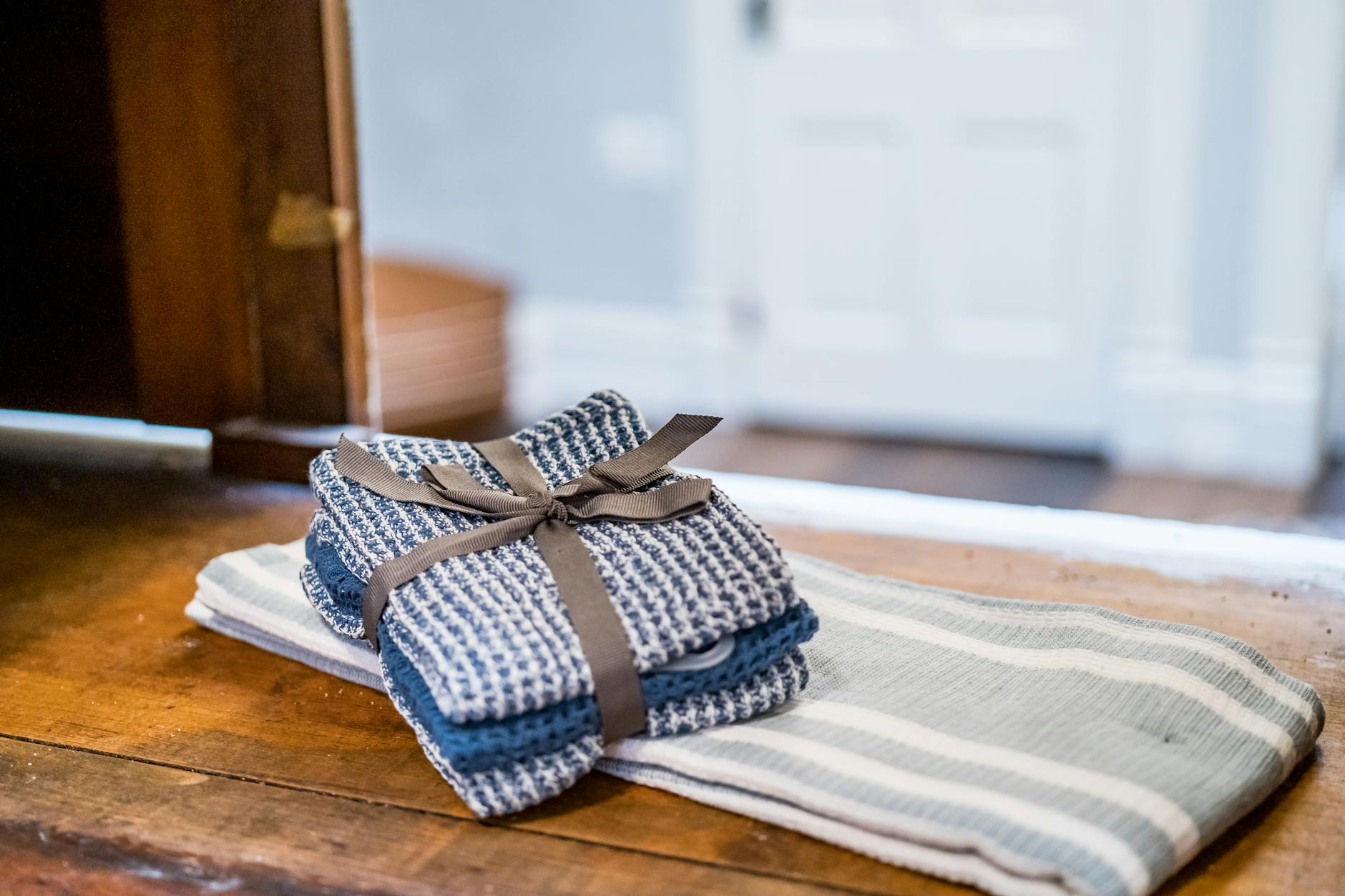 folded kitchen towels beside a simple cutting board in a warm home kitchen