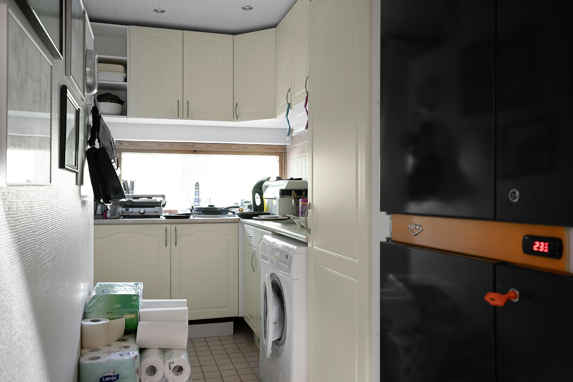 A narrow kitchen cabinet with neatly arranged storage containers and baskets